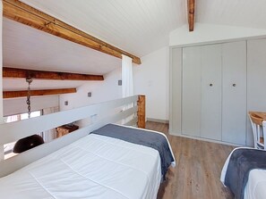 Ein Zimmer mit Etagenbetten, einem Kleiderschrank und einem kleinen Tisch.