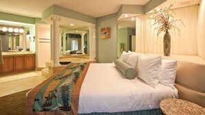 A hotel room with a bed, a vanity with a mirror, and a large window with curtains. - Star Island Resort and Club, just 4 miles from the entrance to Walt Disney World (Kissimmee)