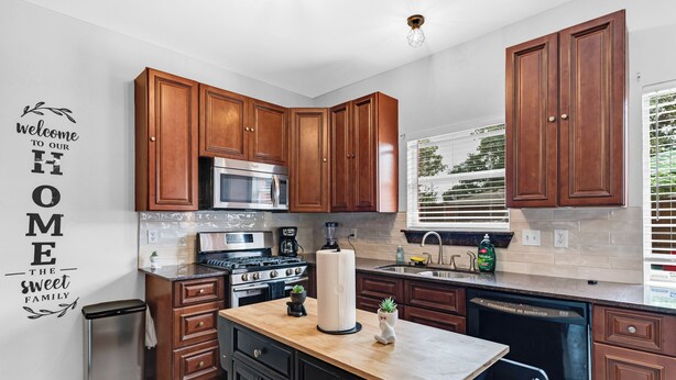 Una cocina moderna con armarios de madera, electrodomésticos de acero inoxidable y una isla central.