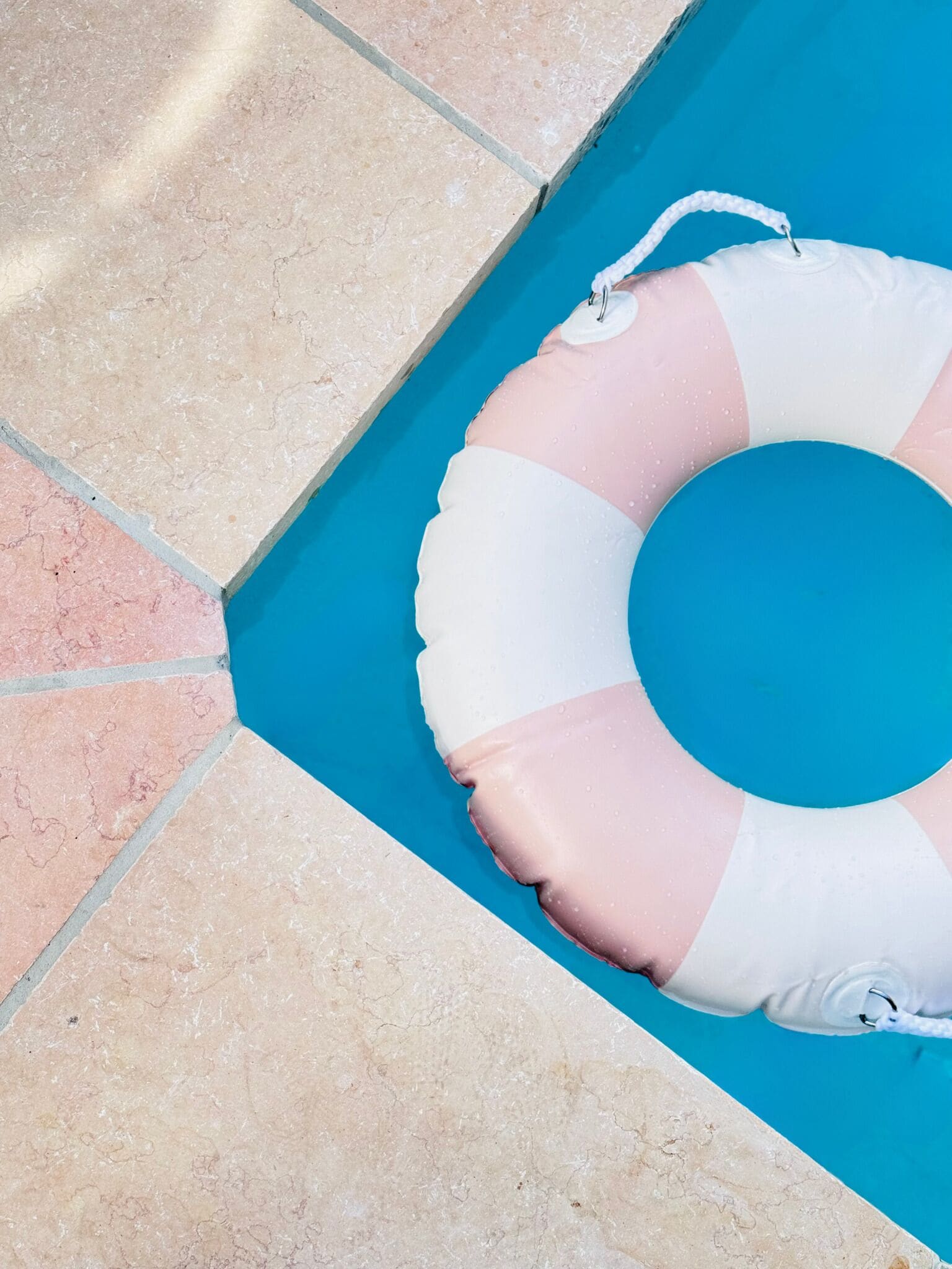 A pool with a pink and white inflatable ring.