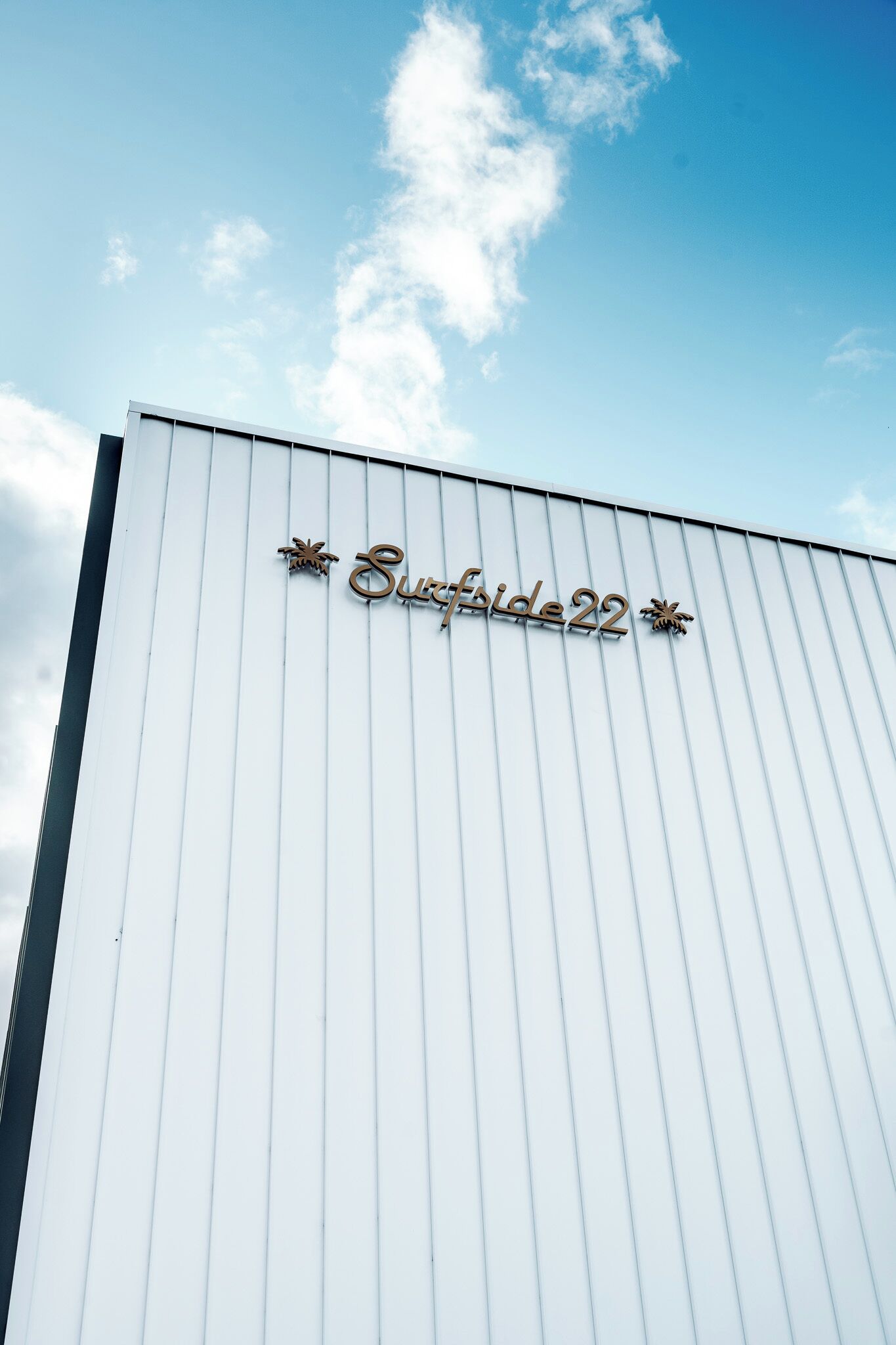 A building with a sign that reads "Surfside 22" against a clear sky.