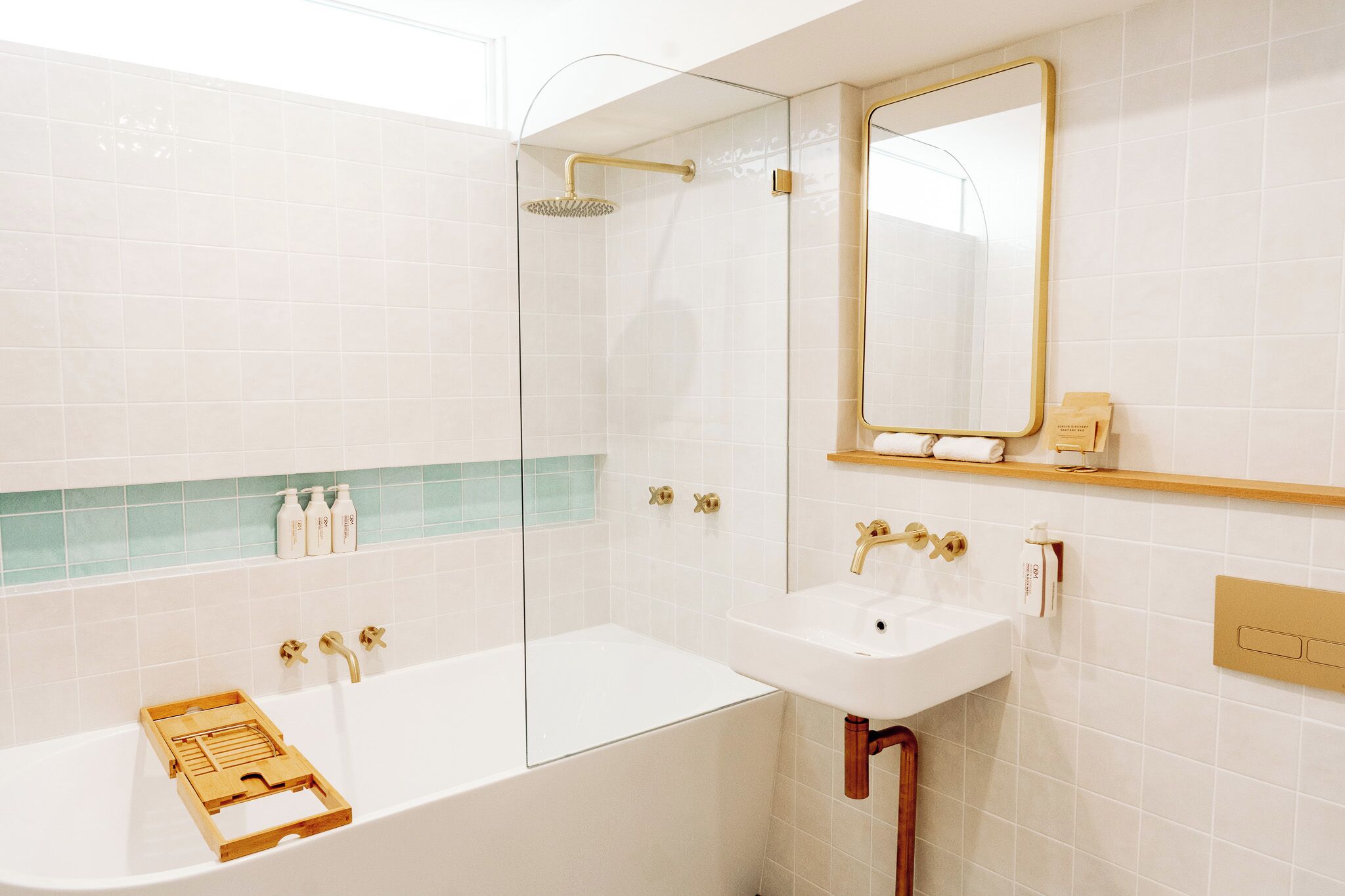 A modern bathroom with a bathtub, a shower, a sink, and a mirror.
