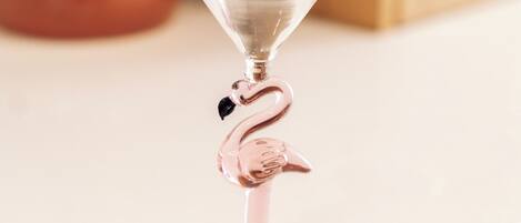 Een helder glazen martini glas met een roze flamingo ontwerp op een witte ondergrond.