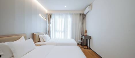 Ein Hotelzimmer mit zwei Betten, einem Schreibtisch und einem Stuhl.