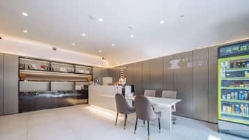 A modern reception area with a counter, seating, and a beverage dispenser.