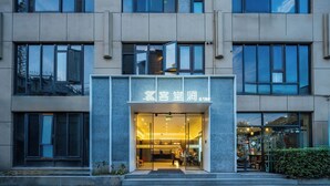 A modern building with a glass entrance and a sign in a foreign language. - Shanghai Ketangjian Apartment Hotel (Shanghai)