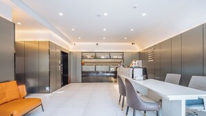 A modern kitchen with a central island, built-in appliances, and a dining area with a long table and chairs. - Shanghai Ketangjian Apartment Hotel (Shanghai)