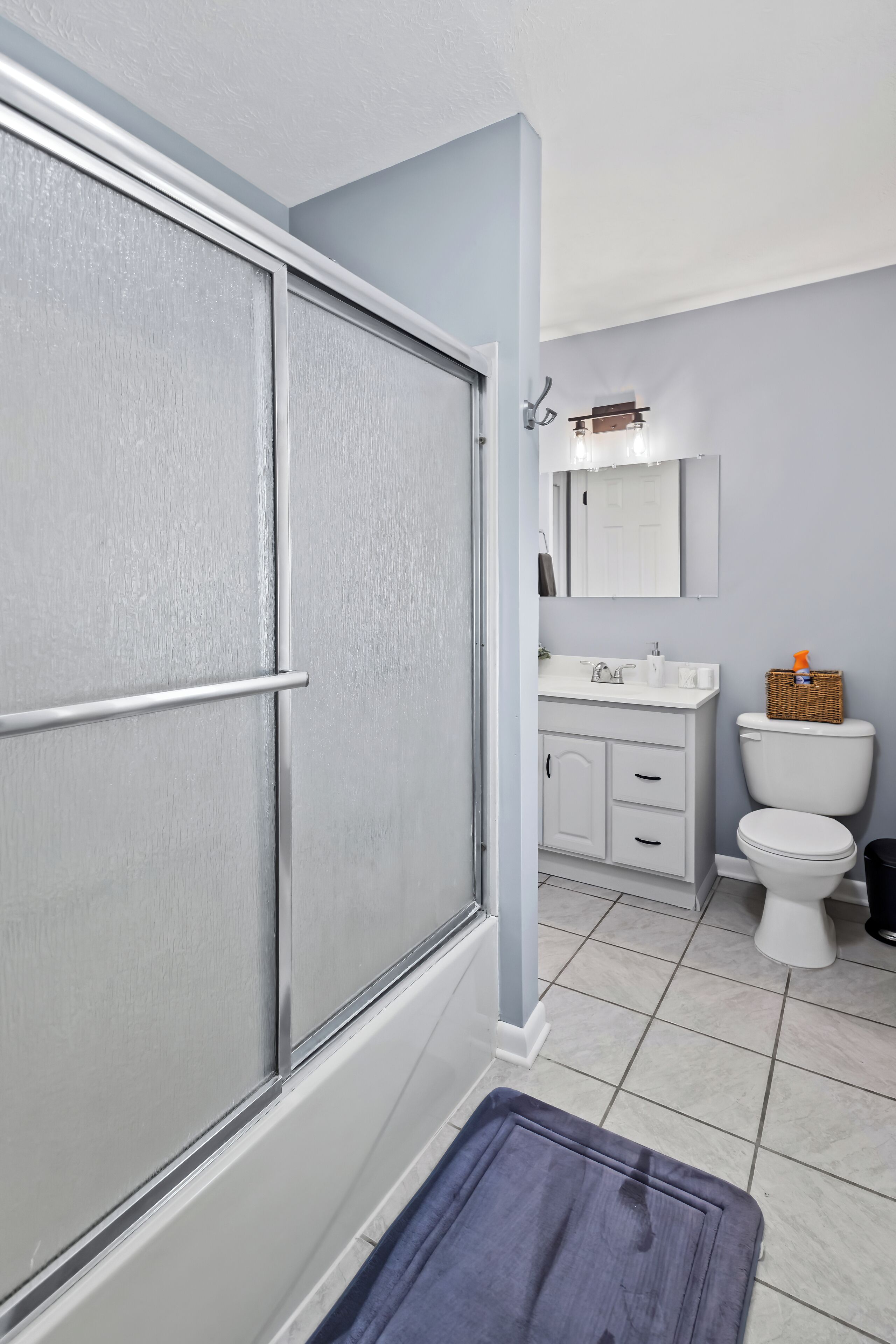 Un baño con ducha, inodoro y lavabo.