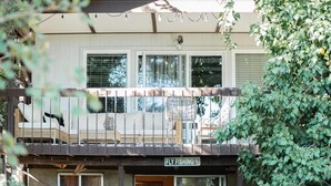 Un edificio de dos pisos con un balcón que tiene muebles de mimbre y un letrero que dice "FLY FISHING".
