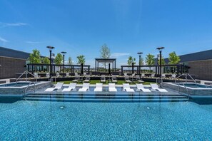 A swimming pool with lounge chairs and a covered seating area. - Deluxe Designer1BR Gym/Pool/HTub (Salt Lake City)