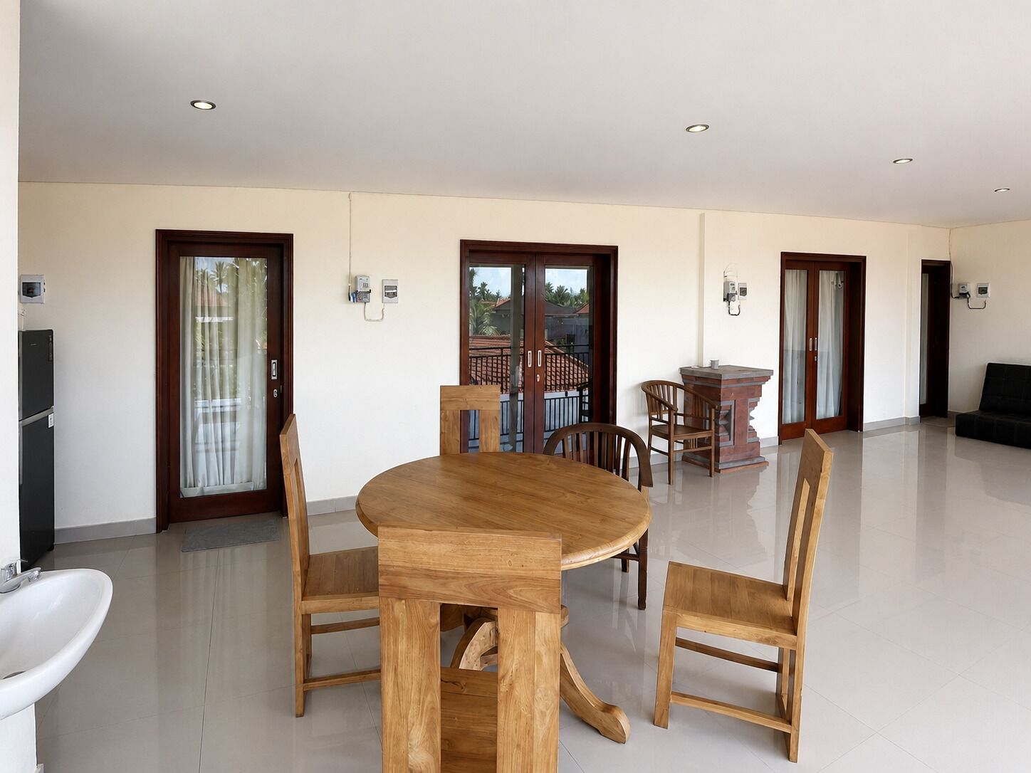 A spacious living area with a wooden dining table, chairs, and a built-in bench.