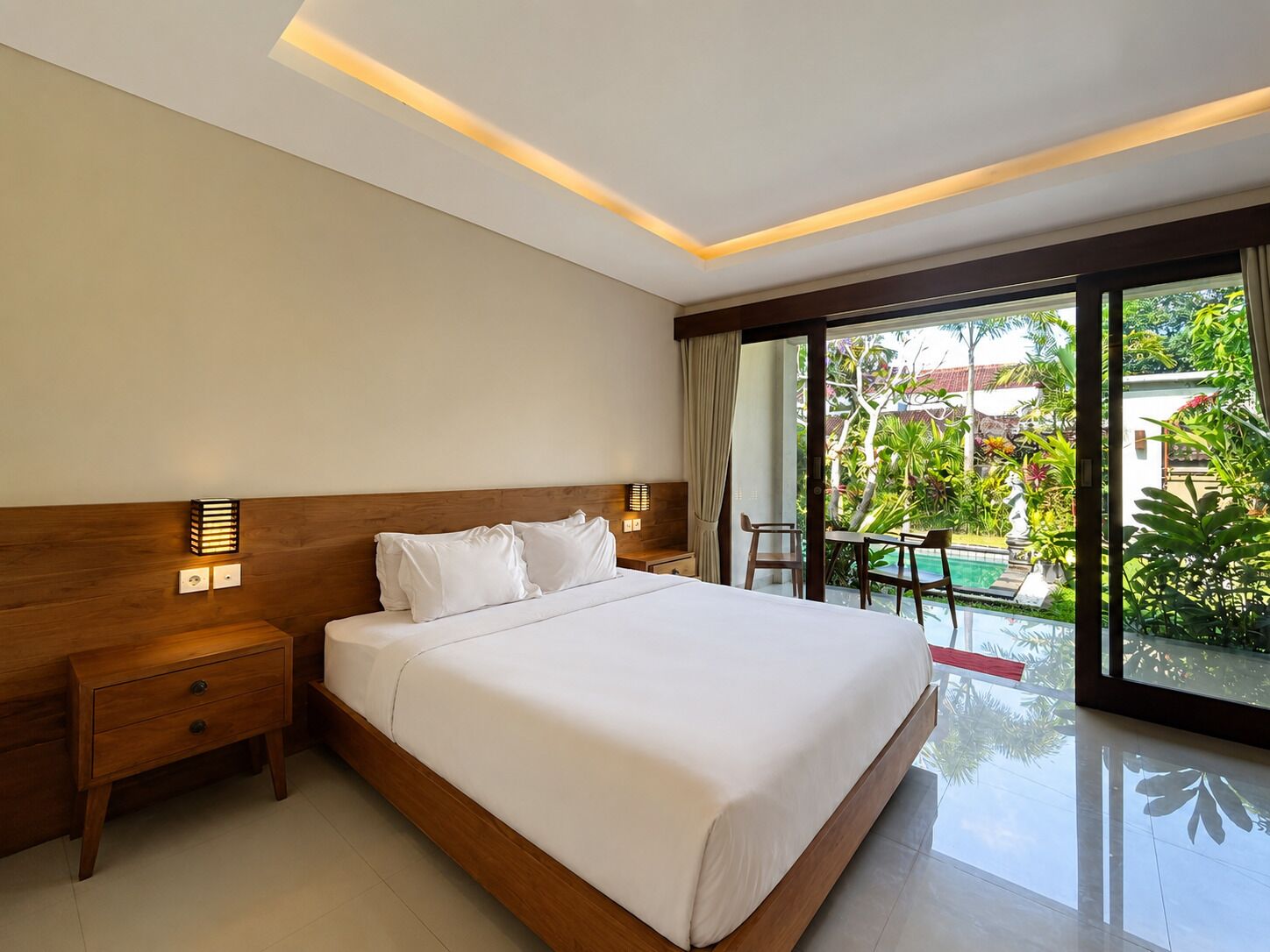 Une chambre d’hôtel moderne dotée d’un grand lit, d’une table de chevet, d’une lampe de chevet et offrant une vue sur une piscine et un espace verdoyant.