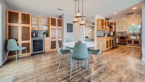 Een moderne keuken met houten kastjes, een eettafel met stoelen en een centraal eiland.