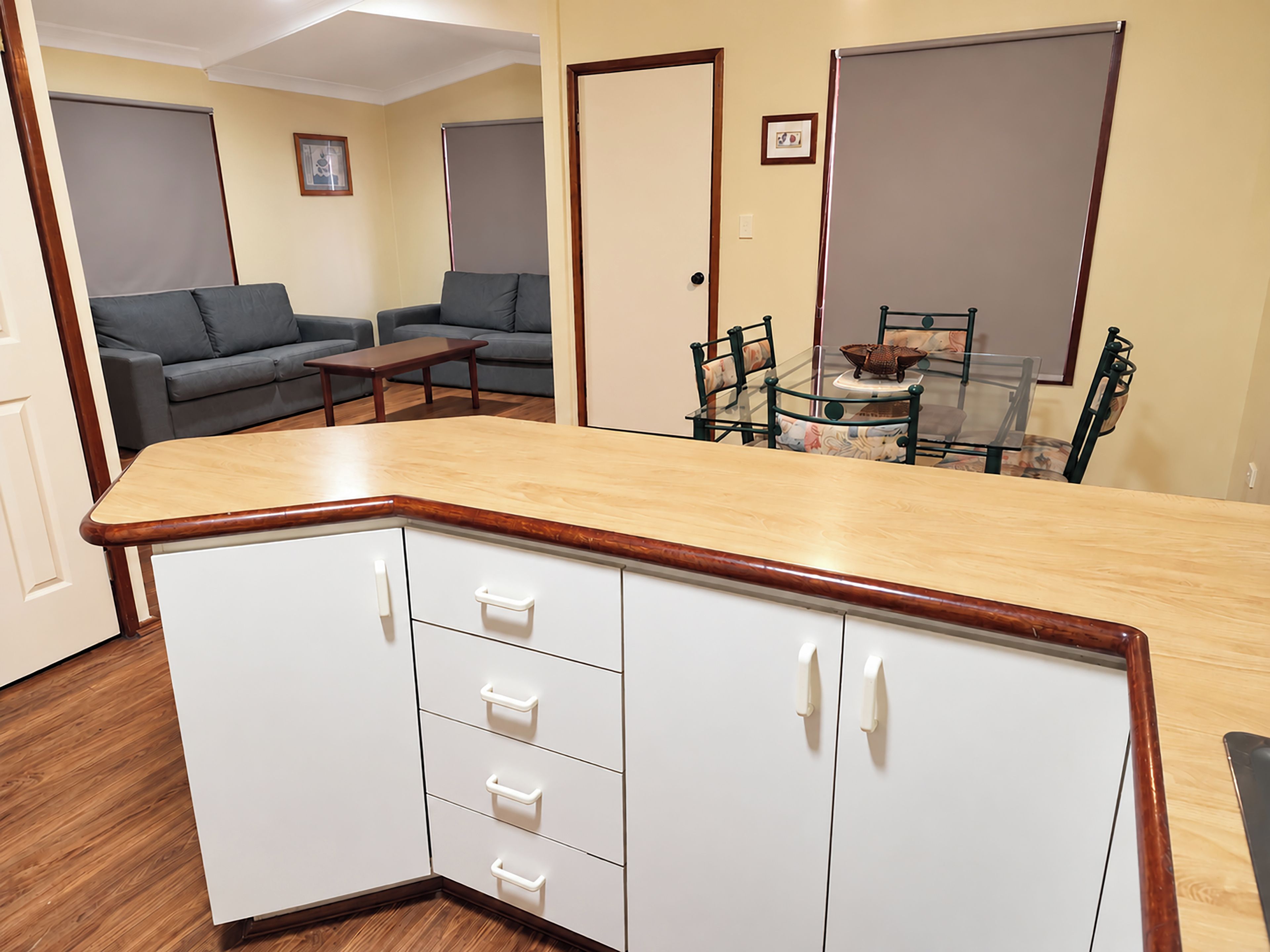 Un espacio habitable compacto con kitchenette, zona de comedor y sala de estar con sofá y mesa.