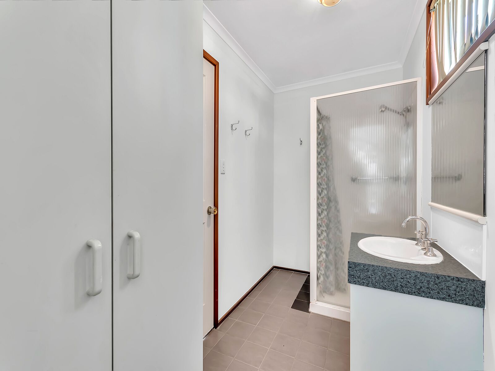 Un baño moderno con ducha, lavabo y espejo.