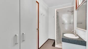 Un baño moderno con ducha, lavabo y espejo.