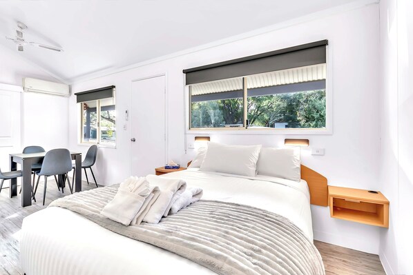 Una habitación de hotel moderna con una cama, un escritorio y sillas.