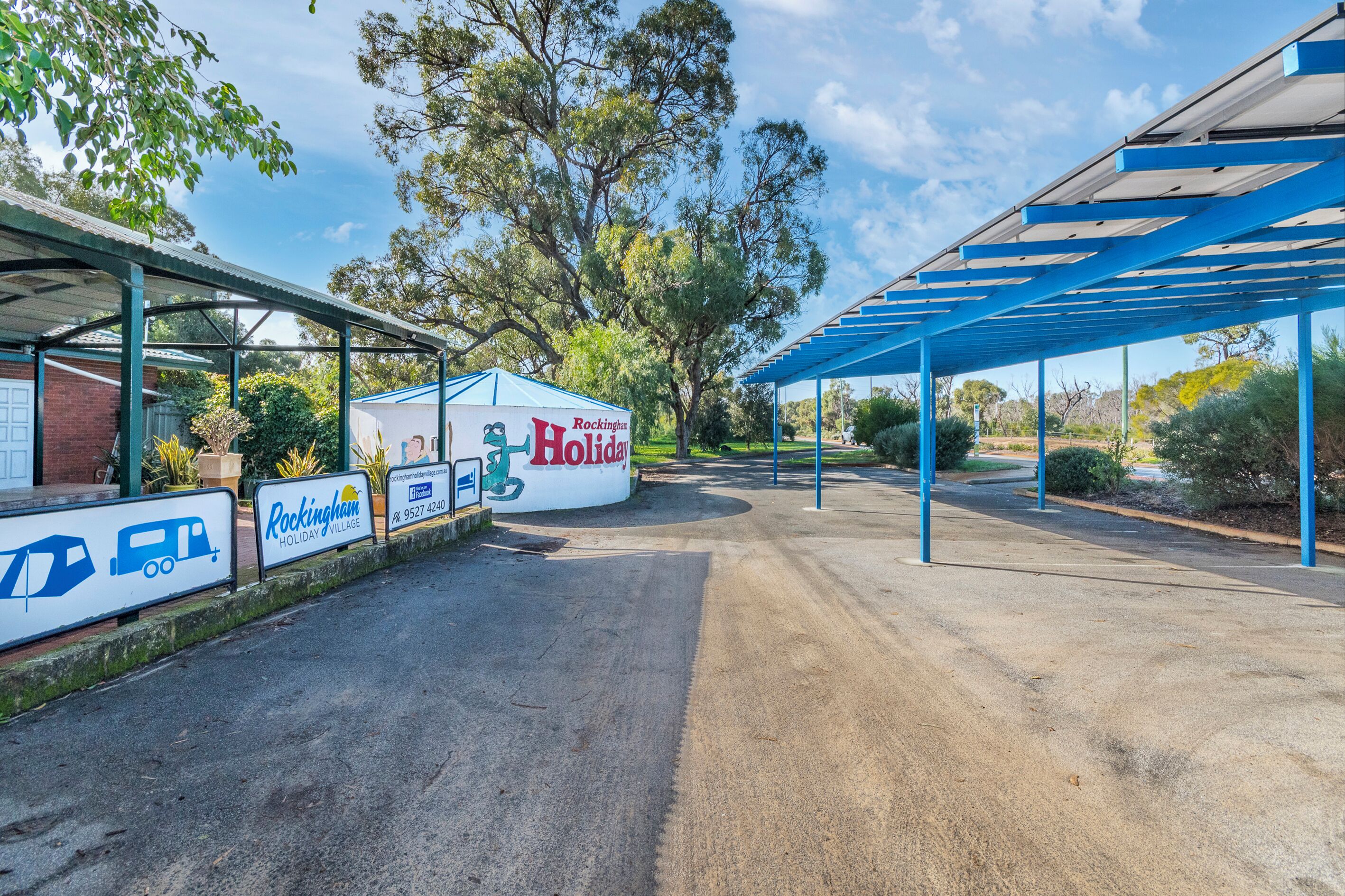 Un área de estacionamiento techada con un letrero que indica Rockingham Holiday Village.