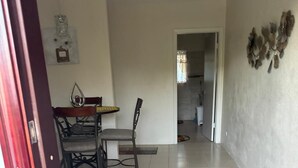 A spacious hallway with a dining area featuring a table and chairs, a patterned rug, and a decorative wall piece. - Cozy apartment in the Eastern District with beautiful views of Nassau (Nassau)