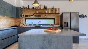 A modern kitchen with a large island, built-in appliances, and a variety of storage options. - Vacation home Bianca by Interhome (Novigrad (Istra))