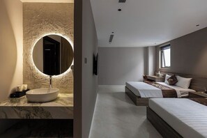 Ein modernes Badezimmer mit einem runden Spiegel und einem мраморному Waschbecken. Der Raum verfügt über ein großes Bett mit einem hölzernen Kopfteil und einen Nachttisch.