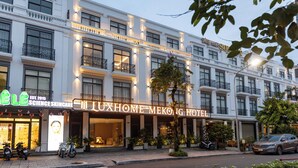 Een meerhoog hotel met een opvallend bord waarop 'LUXHOME MEKOING HOTEL' staat.