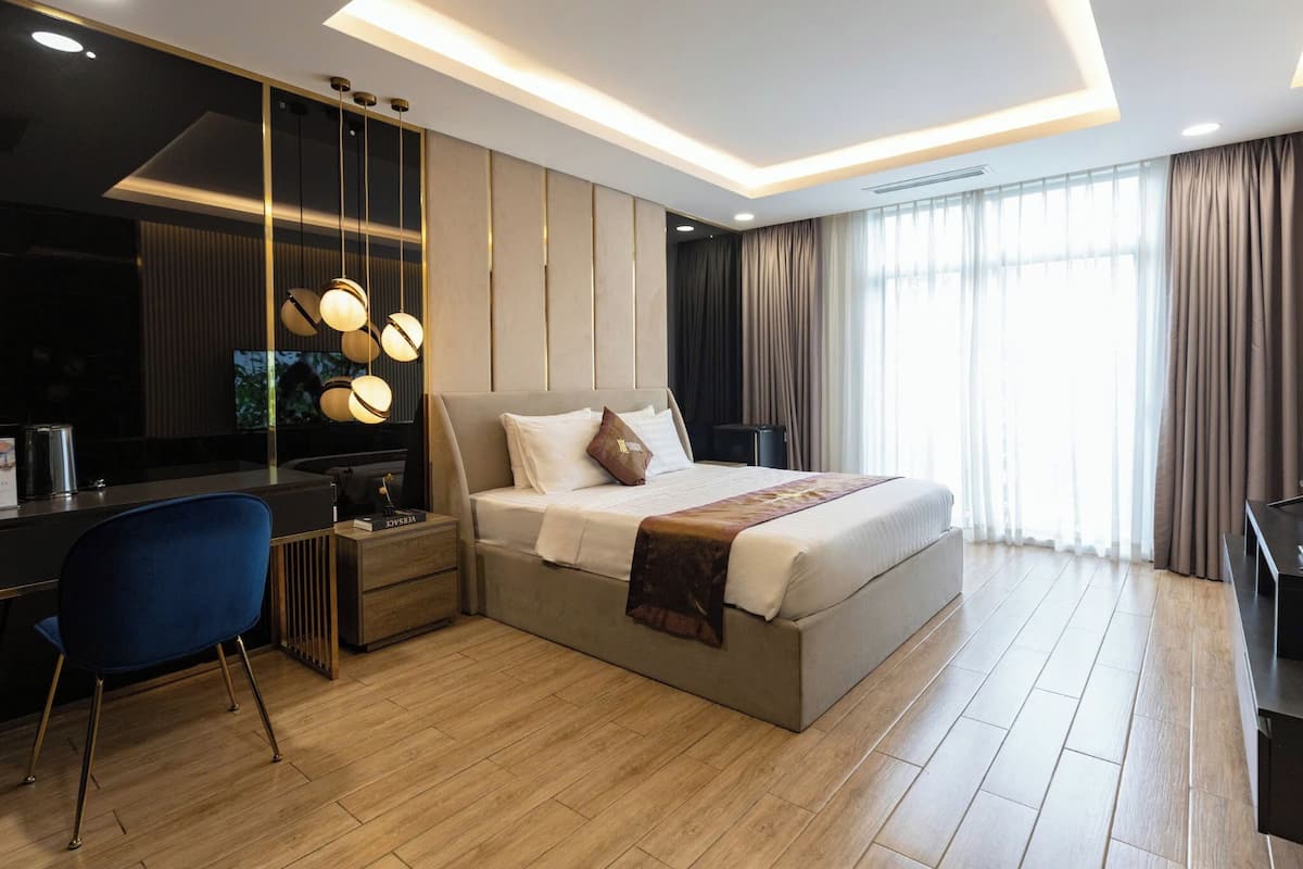 Une chambre d’hôtel moderne avec un grand lit, un bureau et une télévision.