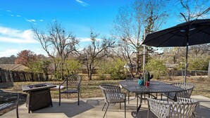 An outdoor patio with a table and chairs, a grill, and a cactus. - Established listing! KSU Sports & Events! Great location for all! 4bd 2ba (Manhattan)