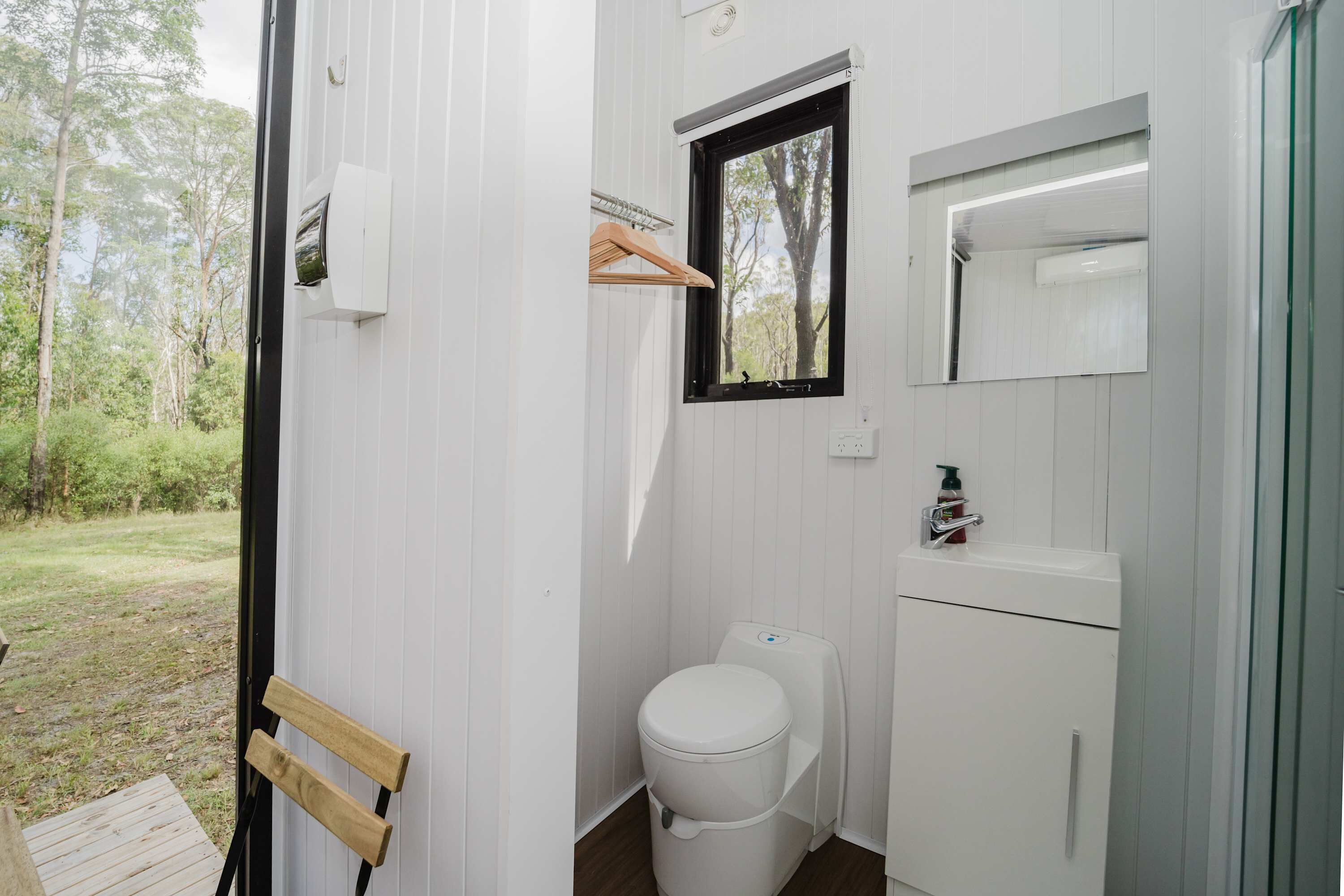 Uma casa de banho pequena com sanita, lavatório e janela.