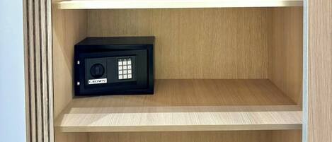 Una habitación con tres estantes de madera y un dispositivo electrónico negro en el estante inferior.