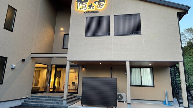 Un hotel moderno con un letrero que dice "HOTEL KAKUREGA" y un acceso cubierto.