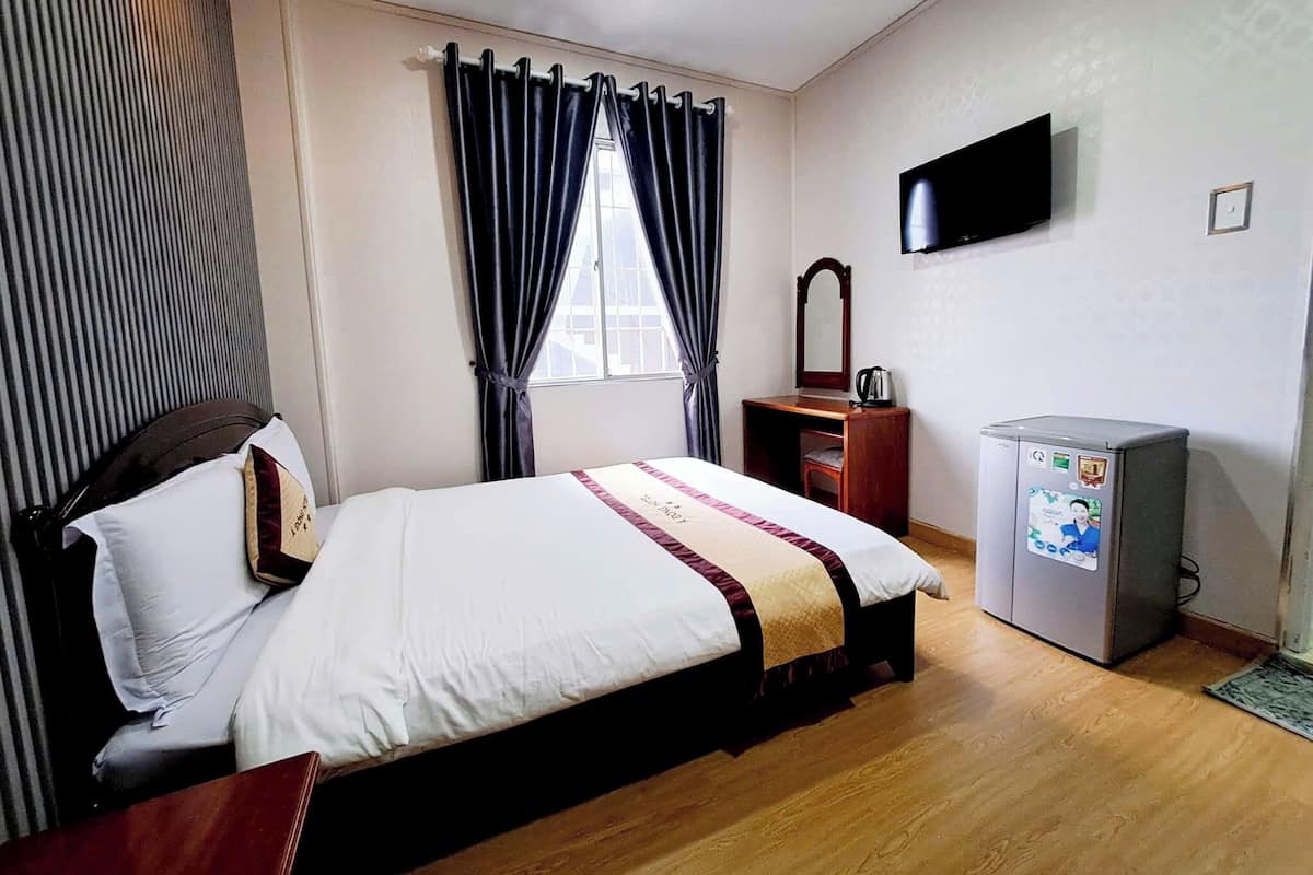 Une chambre d’hôtel équipée d’un lit, d’une télévision, d’un bureau et d’une machine à café.