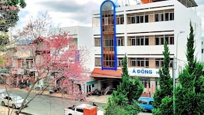 Un edificio de varios pisos con un arco azul llamativo y señalización que dice "A ĐỘNG HÀNH".