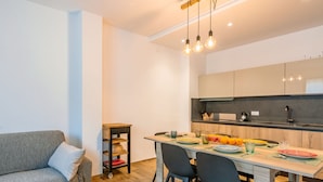 Una cocina moderna con una mesa de comedor, sillas y una mesita auxiliar.