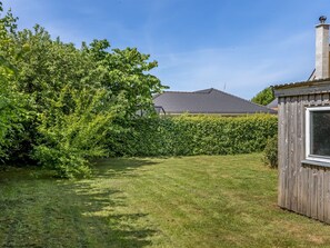 Enjoy the serene atmosphere of this beautifully maintained outdoor space with a tranquil lawn and lush greenery.