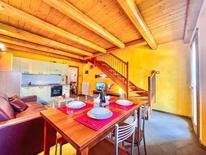 Un intérieur en bois comprenant un coin repas, une cuisine et un escalier.