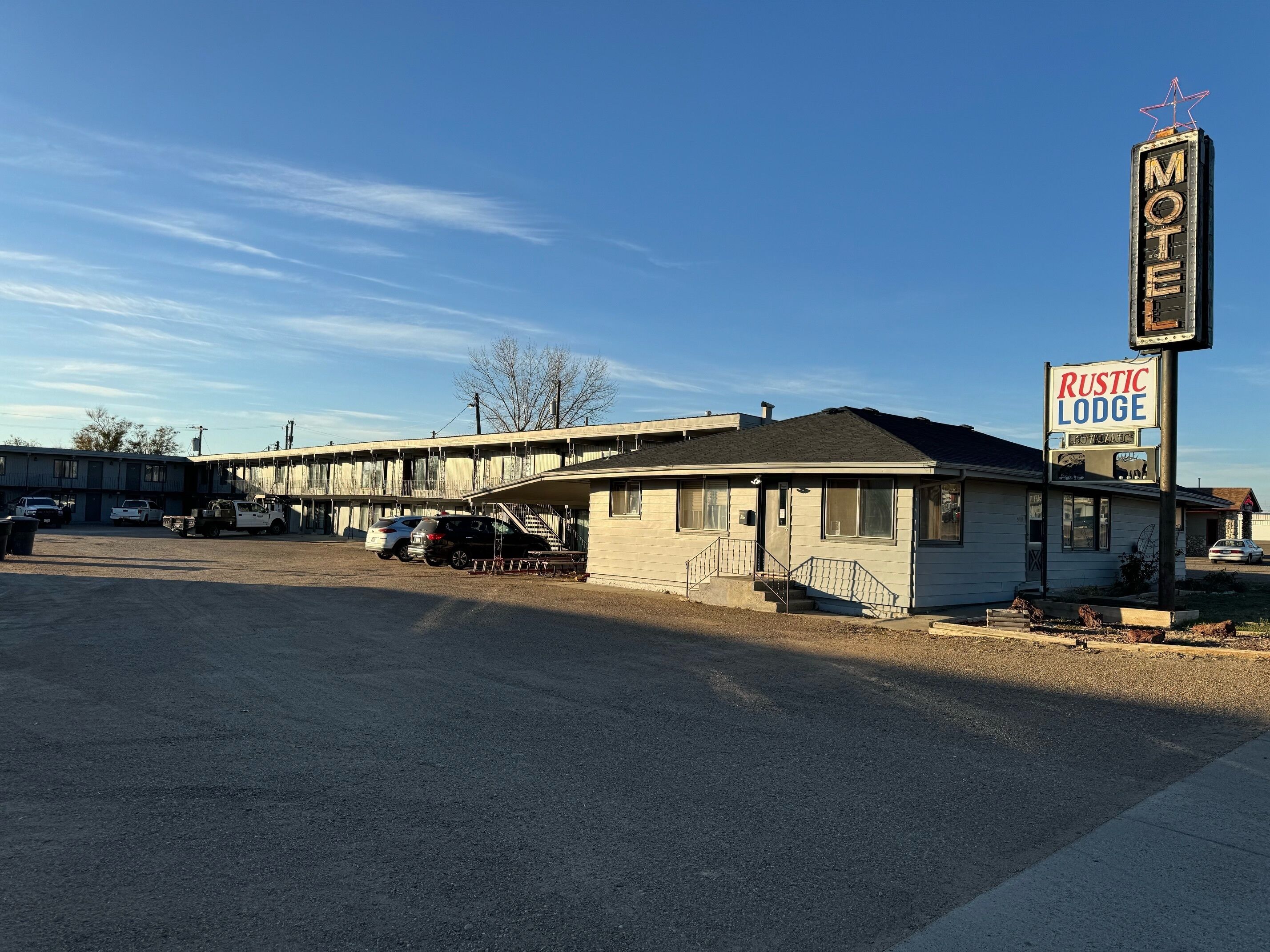 A motel with a sign reading "Rustic Lodge" and "Motel."
