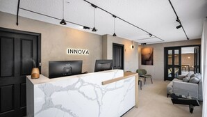 A reception desk with a marble top, two monitors, and a sign that reads "INNOVA". - Innova Motel Warrnambool (Warrnambool)