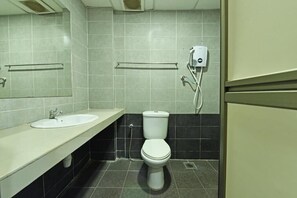 A bathroom with a white sink, a toilet, and a hand dryer. - MRC Hotel Malacca (Malacca City)
