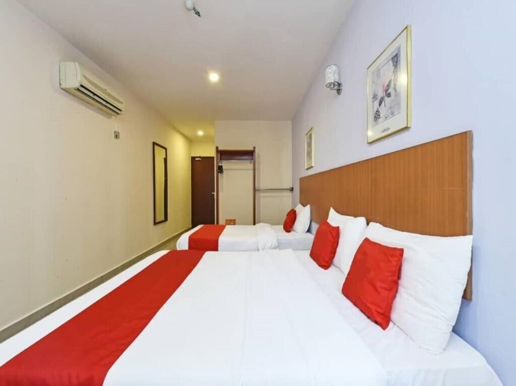 Una camera d'albergo con due letti, una testiera di legno e un quadro incorniciato appeso al muro.