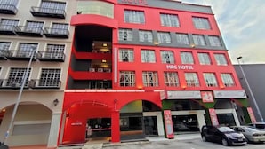 Un hotel de varios pisos con balcones y fachada roja.