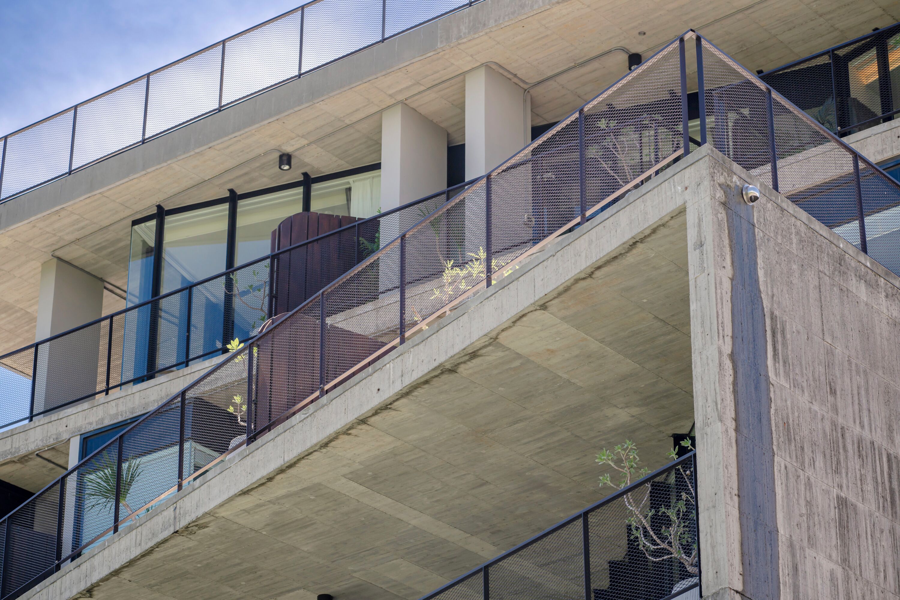 A multi-level concrete building with metal railings and glass windows.