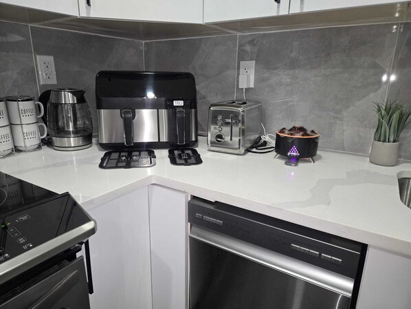 Cocina moderna con cafetera, tostadora y escurreplatos.