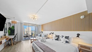 Una habitación de hotel moderna con una cama grande, un escritorio y vistas a la ciudad.