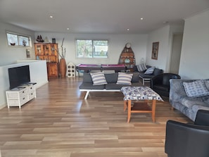 Una sala de estar con mesa de billar, sofás, televisor y chimenea.
