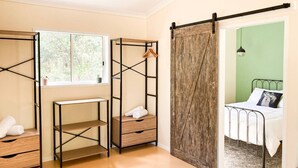 Une chambre avec des lits superposés, un bureau et un lit.