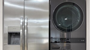 Un refrigerador de acero inoxidable con dispensador de agua e incluye lavadora y secadora.