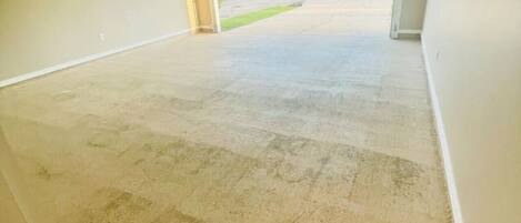 A garage with a concrete floor and a doormat with the word "welcome" on it.
