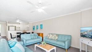 A modern living room with a sofa set, a coffee table, and a TV.