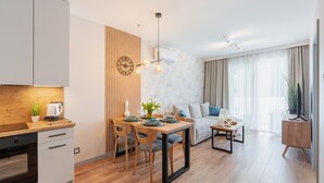 A modern apartment with a kitchen, dining area, and living room. - Apartamenty Sun & Snow Perłowa Przystań Kołobrzeg (Kolobrzeg)